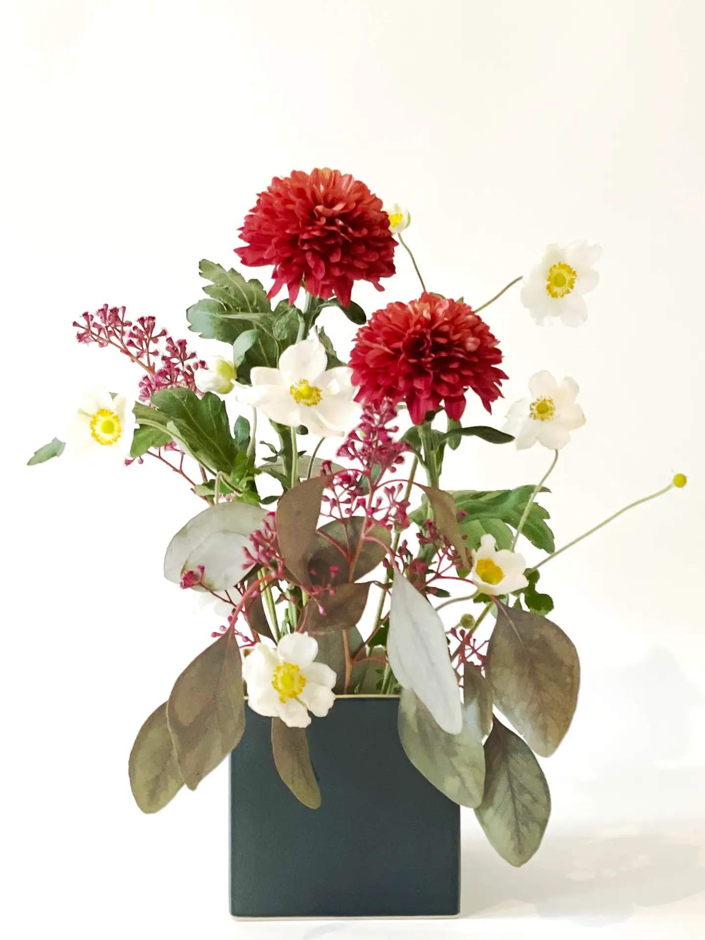 Flower arrangement with red dahlias and white anemones in a square ceramic vase by La Récréation, created by suminumi in Berlin.