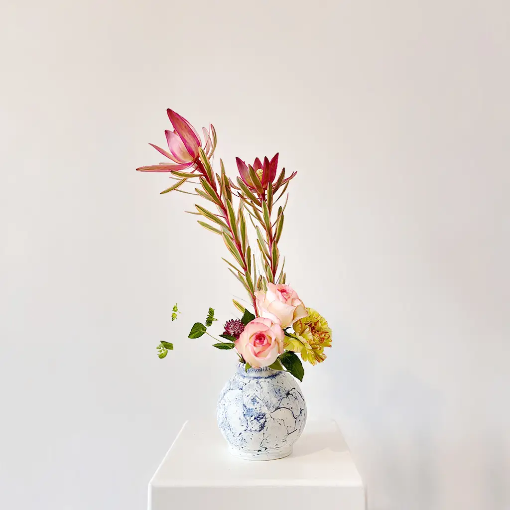 Ikebana flower arrangement with pink protea and roses in ceramic vase – Berlin ikebana workshop example