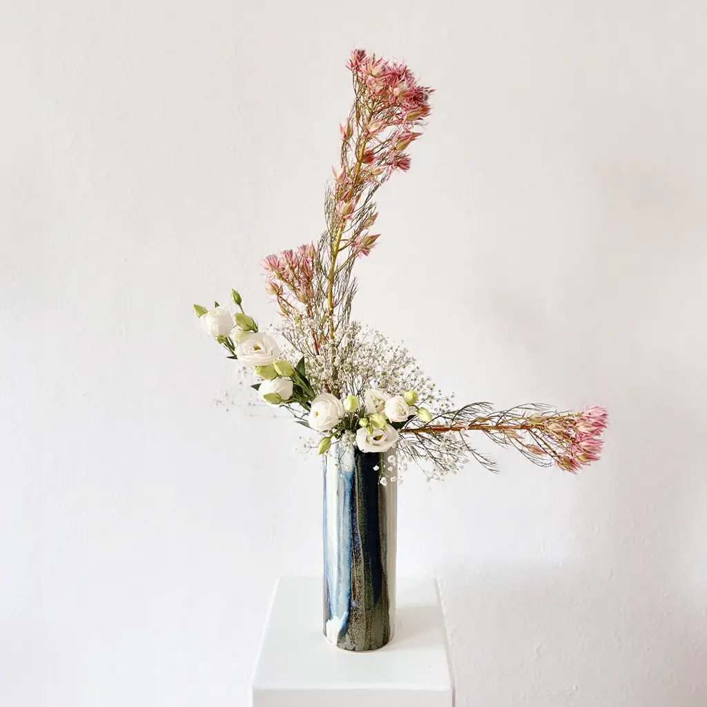 Minimalist ikebana floral design with white roses and textured branches – Japanese flower workshop Berlin