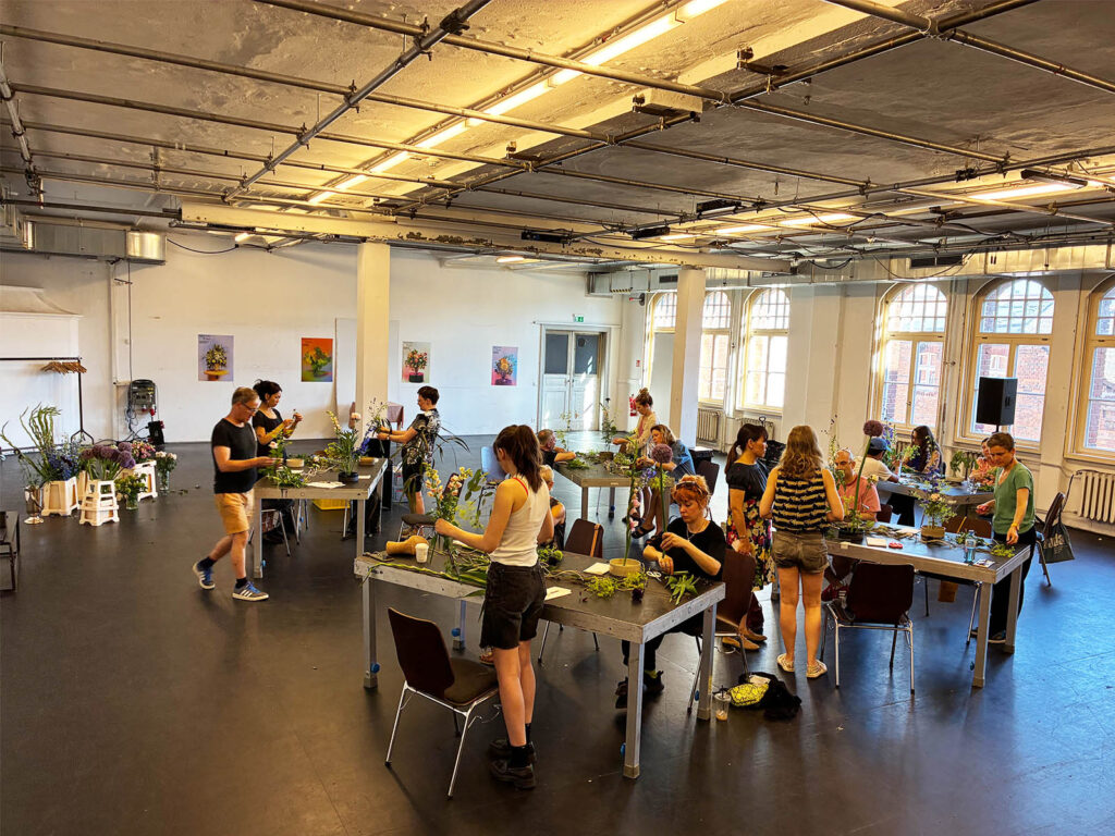 Participants creating Ikebana arrangements during a workshop at Sophiensæle in Berlin